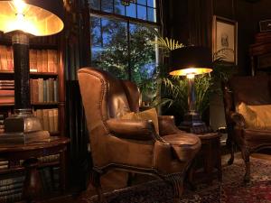 爱丁堡梅菲尔德23号酒店的客厅配有真皮座椅和灯