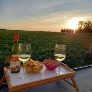 ZottegemDe Molenlos的一张桌子,上面放着两杯葡萄酒和一碗食物