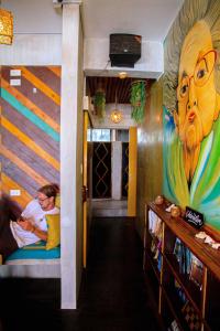 爱妮岛Happiness Hostel El Nido的墙上有画作的走廊,房间里有两个人