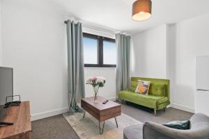 斯劳Heathrow Haven: Stylish Apartments in the Heart of Slough的客厅配有绿色沙发和桌子