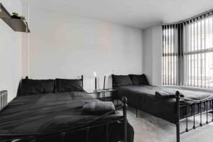 利物浦4 bedroom stylish home central location的一间卧室设有两张床和大窗户