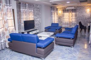 洛美Grand appartement lomé centre ville mer clim 6pers的一间设有蓝色椅子和平面电视的等候室