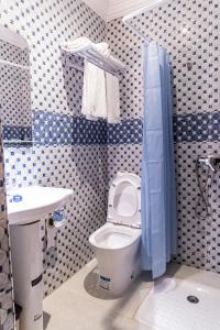廷吉尔HOTEL LA VALLEE DES KASBAHS CHEZ ILYAS的蓝色和白色的浴室设有卫生间和水槽