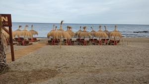 卡拉德米哈斯Loft La Cala de Mijas beach estudio mirando al mar的海滩上的一把稻草遮阳伞和椅子