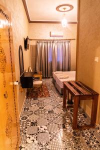 廷吉尔HOTEL LA VALLEE DES KASBAHS CHEZ ILYAS的客房铺有瓷砖地板,配有一张床和一张桌子。