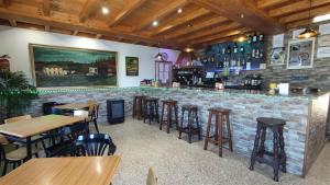 蒂内奥Pension Parrilla Casa Vicente的餐厅内的酒吧,设有桌子和凳子