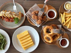 曼谷Kokotel Bangkok Dheva Thonglor的配上盘子的桌子,配上洋葱环和薯条