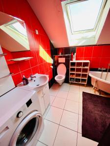 新松奇Komfortowy pokój dla dwojga z balkonem Marcinkowicka的红色的浴室设有洗衣机和水槽