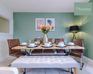 巴斯Huge Four Bedroom Townhouse By PureStay Short Lets & Serviced Accommodation Bath的餐桌、椅子和花瓶