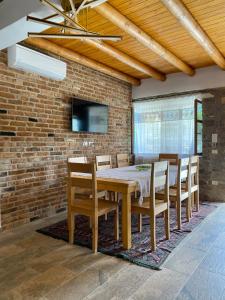 培拉特Vila Ramaj的一间设有桌椅和砖墙的用餐室
