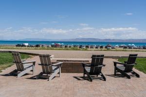 加登城Sun Outdoors Garden City Utah的三把椅子和一张桌子以及一张长凳和海滩