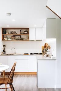CarrickThe Stable Lofts的厨房配有白色橱柜和桌子