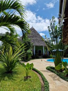 迪亚尼海滩Paradiesische Villa Maisha Mazuri mit Pool. Terrasse und Personal的一个带游泳池和棕榈树的度假村