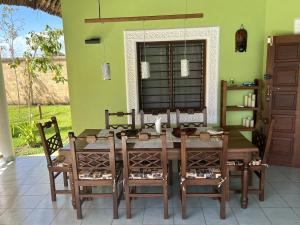 迪亚尼海滩Paradiesische Villa Maisha Mazuri mit Pool. Terrasse und Personal的一间带木桌和椅子的用餐室