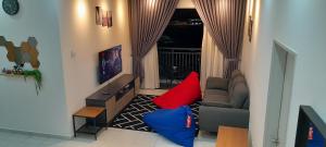 加影D'Homestay Adelia Residence Bangi Avenue的客厅配有沙发和红色及蓝色枕头。