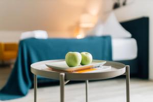 比勒费尔德Stadt-Appartement CityLife的桌子上盘子上两颗绿色苹果