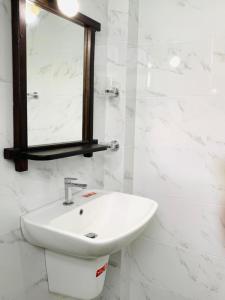达瓦拉维孔雀别墅度假村的白色的浴室设有水槽和镜子