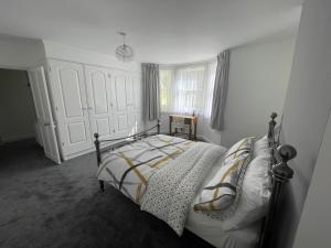 伊斯特布恩Garden flat in 'Little Chelsea'的卧室配有带白色墙壁和窗户的床