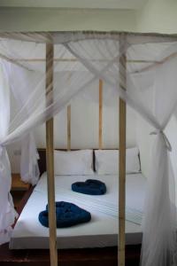 江比阿Pamoja Beach Stays Hotel in Jambiani的一张带白色床单和蓝色枕头的床