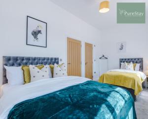 伯明翰Stunning Central House By PureStay Short Lets & Serviced Accommodation Birmingham的一间卧室配有一张带蓝色和白色棉被的床