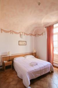 维科福尔泰波尔缇齐酒店的卧室设有一张白色大床和一扇窗户。