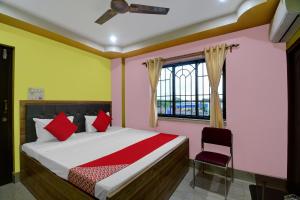 加尔各答Hotel Mahal And Restaurant Kanchrapara的一间卧室设有一张床、一个窗口和一把椅子