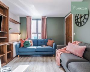 曼彻斯特Stunning Five Bedroom House By PureStay Short Lets & Serviced Accommodation Manchester With Free Parking的客厅设有蓝色的沙发和窗户。