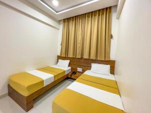 普杰Hari Om Residency的小型客房 - 带2张床和窗户