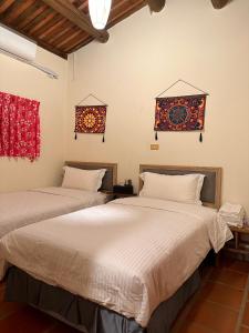 金城永乐古厝民宿的一间卧室设有两张床和两个窗户。
