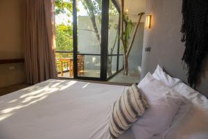 图卢姆BAU Tulum的窗户间内的一张带两个枕头的床