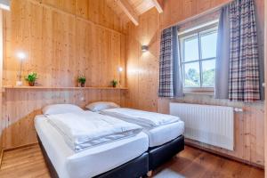 迈斯霍芬菲林澳博雷酒店的配有木墙和窗户的客房内的两张床