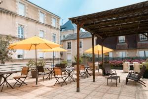 普瓦捷贝斯韦斯特普瓦捷酒店的一个带桌椅和黄色遮阳伞的庭院