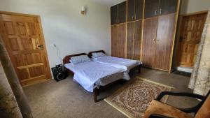 Karimabad HunzaAmn e Yal- Private Family Residence in Hunza的一间卧室配有一张床和一些木橱柜。