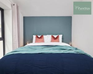 曼彻斯特Stunning 5 Bed House By PureStay Short Lets & Serviced Accommodation Manchester With Parking的蓝色卧室,配有红色枕头的床