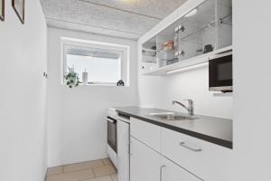 斯文堡Kastanievejens overnatning的白色的厨房配有白色橱柜和水槽