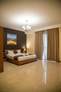 朱菲尔Juffair Trends Luxury Apartment的一间带一张床和吊灯的大卧室