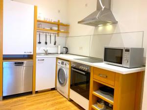 科隆Alles komplett: Zwei Schlafzimmer, große Küche, eigenes Bad的厨房配有微波炉、洗衣机和烘干机
