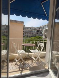 尼斯Nice appartement Avenue des Fleurs的阳台的天井配有桌椅