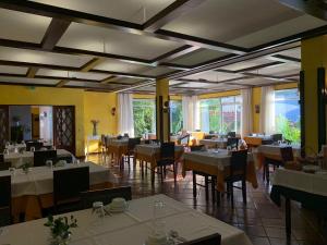 卡尔德拉斯Corredoura Garden的餐厅设有白色的桌椅和窗户。