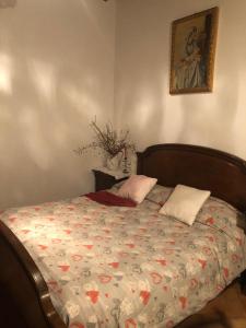 锡耶纳La Belle Maison的一张带两个枕头的床和一张墙上的照片