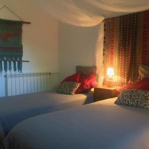 PieraVi l'Art Wine Lodge的一间卧室配有两张床和一张带台灯的桌子