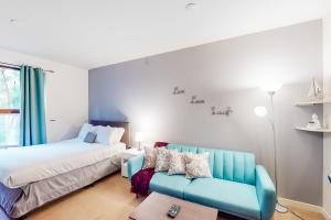 圣地亚哥The Golden Poppy的一间卧室配有一张床和一张蓝色的沙发