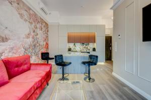 什切青Allure NOVA Aparthotel的客厅配有红色的沙发和桌子