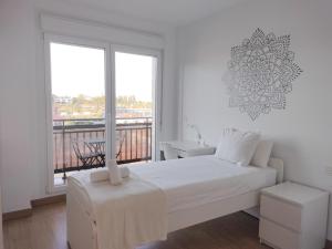贝梅奥Apartamento PATXIKE con plaza de garaje的一间白色卧室,配有床和阳台