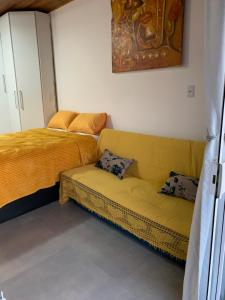 佩尼亚Canto Gira Sol - Suíte Flor的客厅配有沙发和1张床