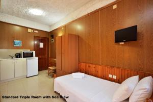 干尼亚Katerina Rooms for Rent的卧室配有一张床铺,墙上配有电视