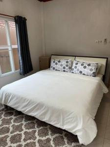 卡图Kathu Home with Mountain View的卧室配有带枕头的白色床和窗户。