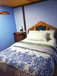 安巴托Hospedaje Dulce Piedad的一间卧室配有一张大床和木制床头板