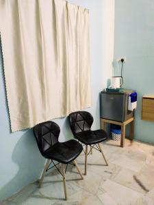 KaparKapar Homestay@Master Room/Private Bathroom/Private Car Park/1-2pax的两把黑色椅子,位于带窗帘的房间
