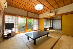 高野山高野山 宿坊 宝城院 -Koyasan Shukubo Hojoin-的客厅配有桌子和电视